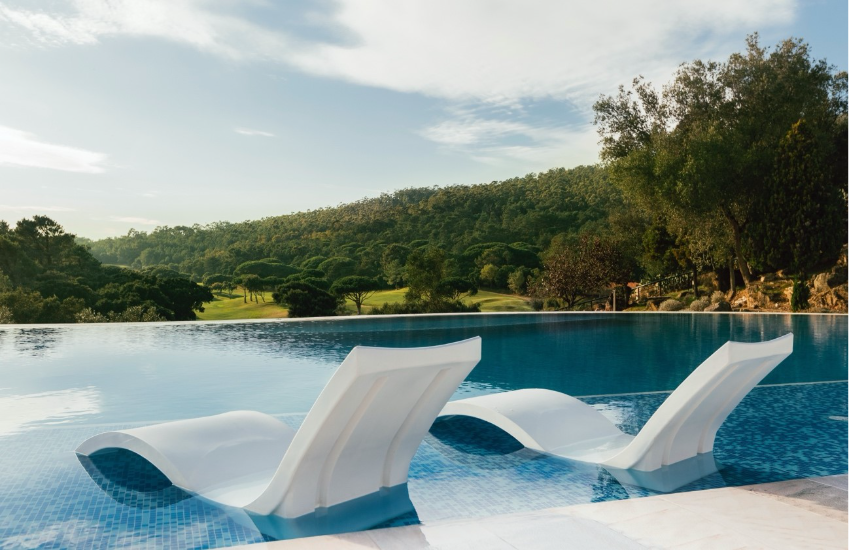 10 piscinas de sonho em Portugal para desacelerar e mergulhar Espreguicadeiras junto a piscina do Penha Longa Resort com vista para a Serra de Sintra