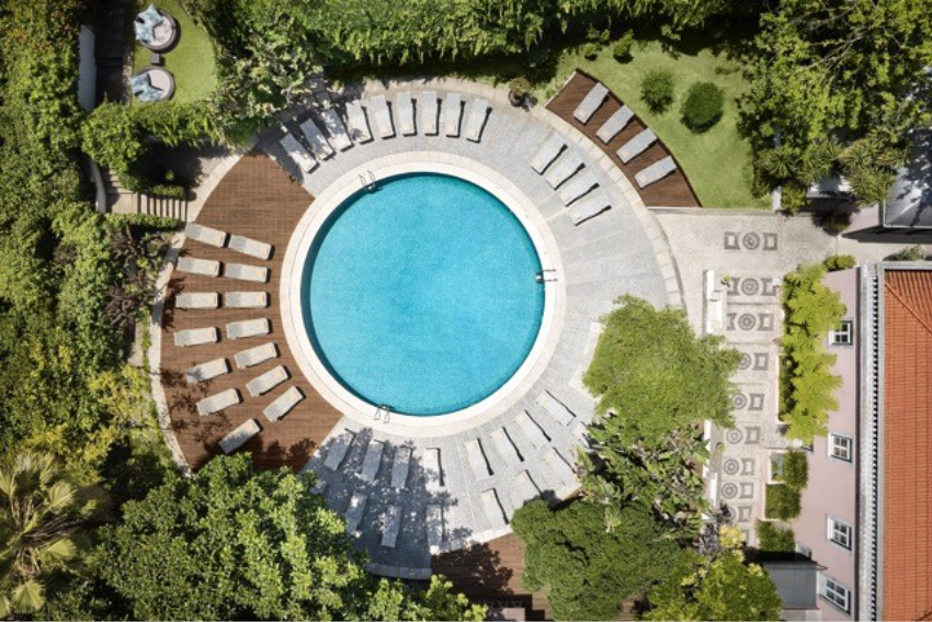 10 piscinas de sonho em Portugal para desacelerar e mergulhar Piscina redonda do Tivoli Avenida Liberdade rodeada de vegetacao em Lisboa